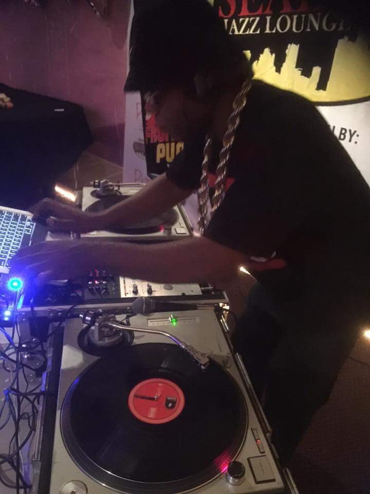 DJ performing on stage under spotlight